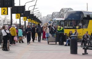 Cilvēki gaida autobusus Rīgas starptautiskajā autoostā pie peroniem