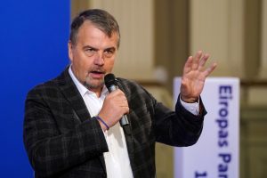 Ivars Ijabs runā mikrofonā pie Eiropas Parlamenta stenda