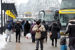 Pasažieri autoostā pie “Ecolines” autobusiem ziemas laikā.