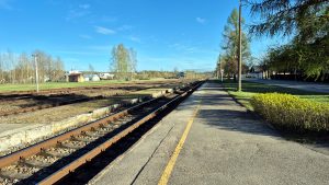 Dzelzceļa sliedes un perons mazā stacijā saulainā laikā
