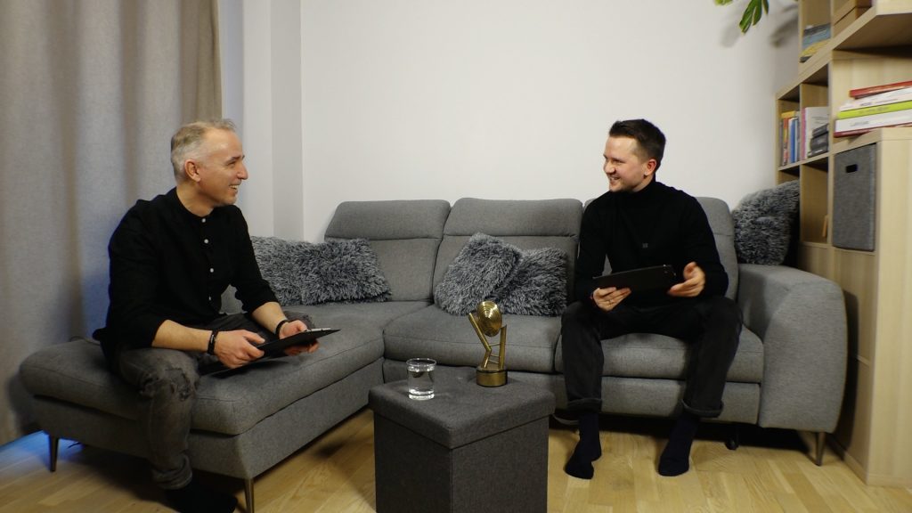 Atis Zviedris intervē Nikolaju Puzikovu studijā, abi sēž uz dīvāna ar planšetēm rokās