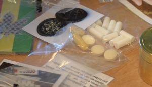 Dažādas nelegālas vielas un tabletes plastmasas maisiņos uz galda