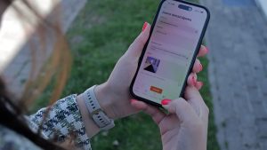 Cilvēks telefonā izmanto Siguldas aplikāciju ziņošanai par graustu