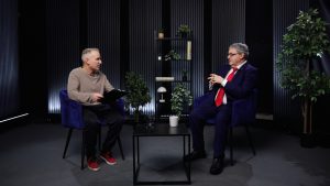 Atis Zviedris intervē Žoržu Siksnu televīzijas studijā, abi sēž krēslos un sarunājas