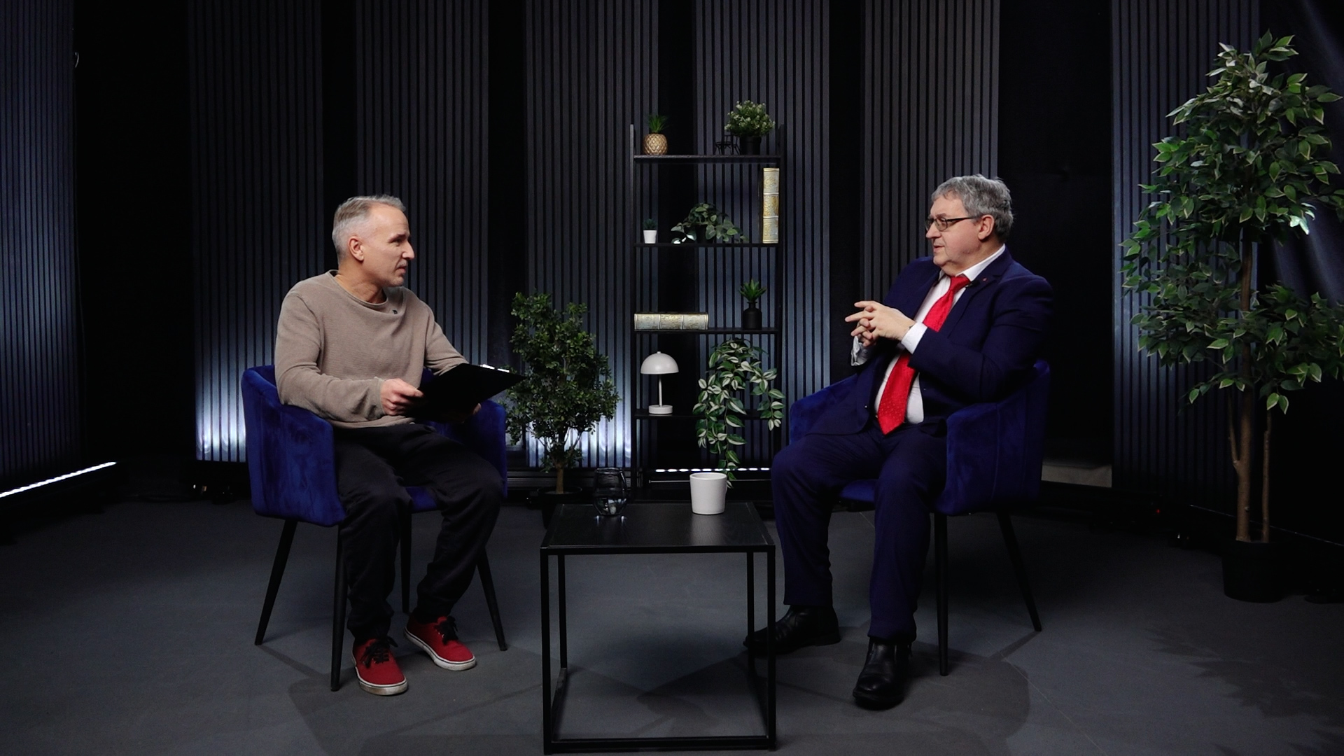 Atis Zviedris intervē Žoržu Siksnu televīzijas studijā, abi sēž krēslos un sarunājas