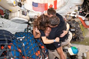 Četri astronauti bezsvara stāvoklī apskāvušies kosmosa kuģa iekšpusē