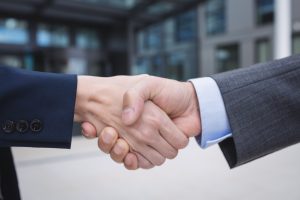 Divi cilvēki spiež rokas biznesa vai politikas vidē