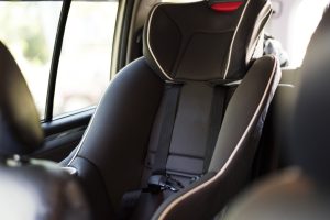 Bērnu autosēdeklis automašīnas aizmugurē ar drošības jostām