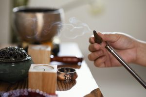 Kvēpināmais vīraks rokā ar dūmiem mierīgā relaksācijas vidē