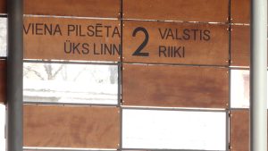 Uzraksts “Viena pilsēta, 2 valstis” uz sienas Valkā