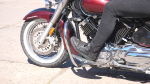 Motocikla tuvplāns ar braucēju, kas sēž uz sarkanā motocikla ar hromētām detaļām.
