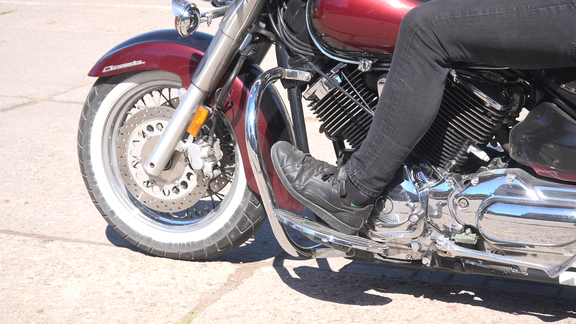 Motocikla tuvplāns ar braucēju, kas sēž uz sarkanā motocikla ar hromētām detaļām.