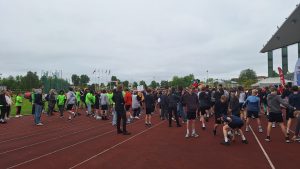 Skolēni un jaunieši pulcējas stadionā sporta pasākuma laikā