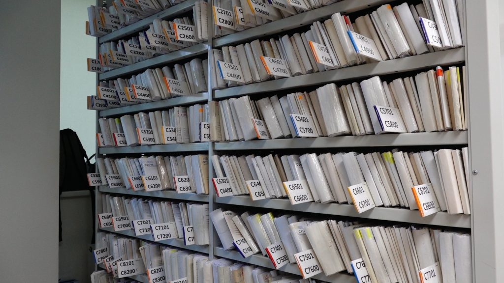 Plaukti ar pacientu medicīniskajām kartītēm reģistratūrā.