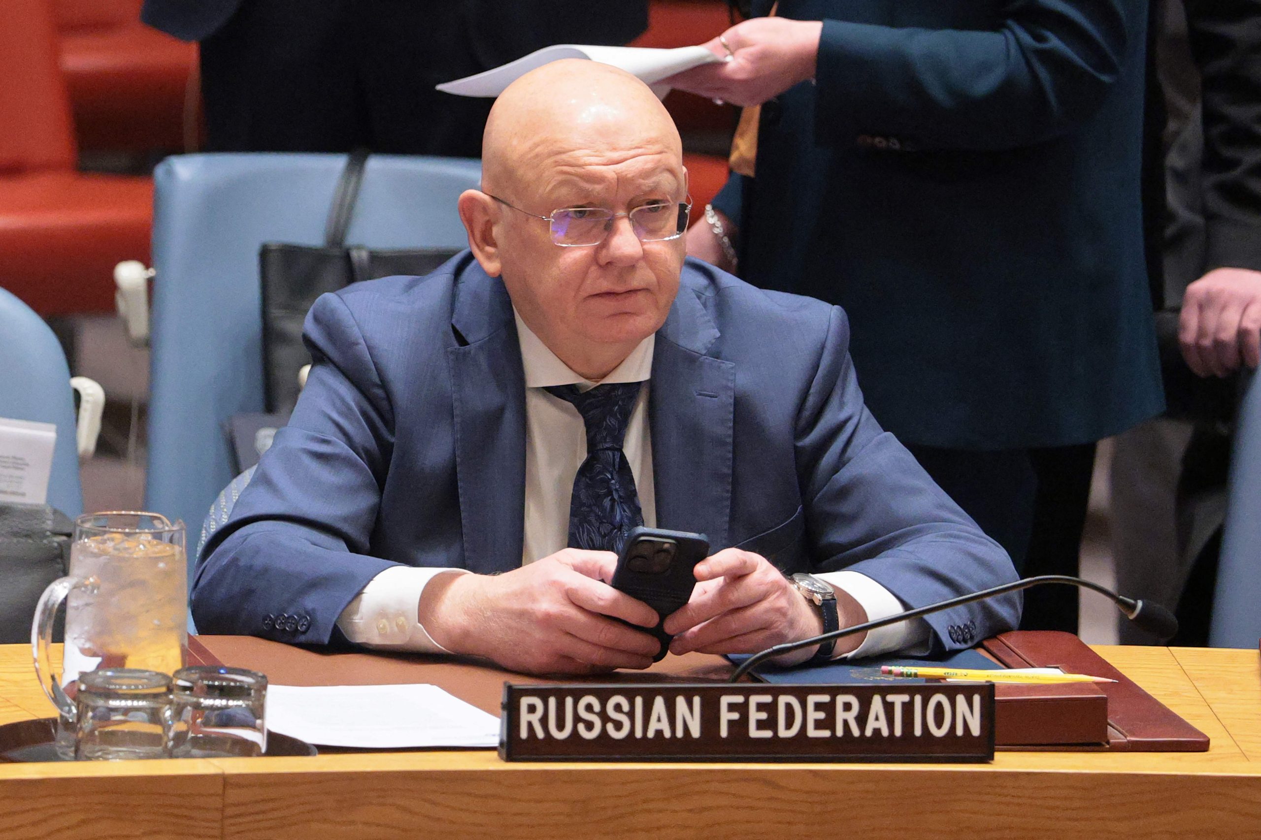 Krievijas pārstāvis ANO Drošības padomes sēdē sēž pie galda ar uzrakstu “Russian Federation”.