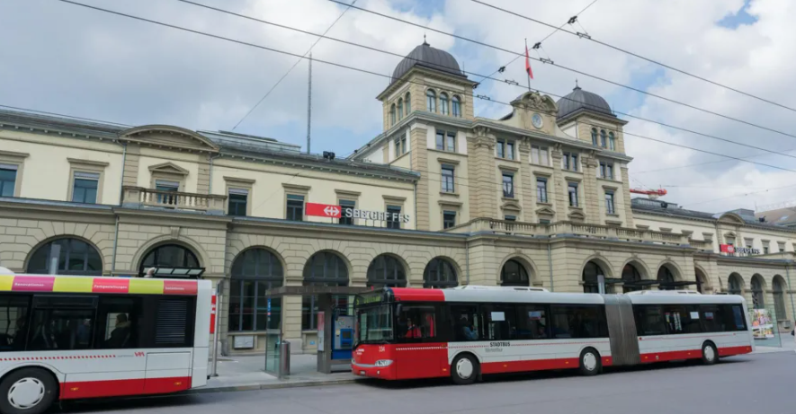 Vintertūras dzelzceļa stacija Šveicē, kur pie ēkas redzams sabiedriskais transports.