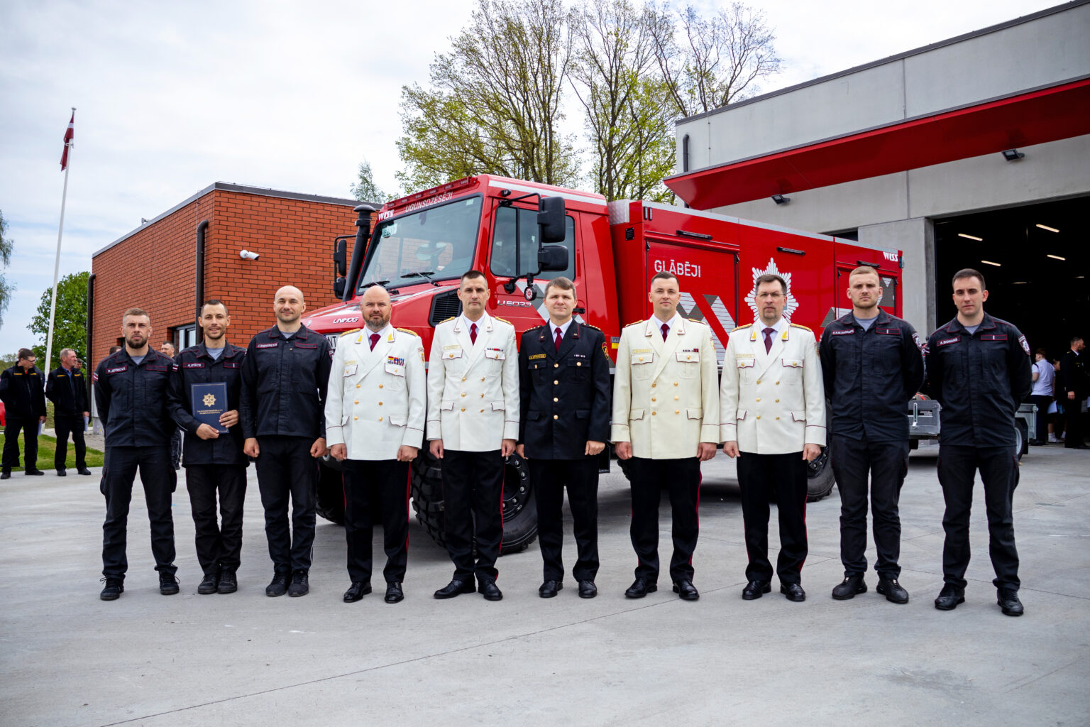Jaunjelgavas posteņa ugunsdzēsēji un VUGD pārstāvji pie ugunsdzēsēju auto pēc apbalvojumu pasniegšanas.