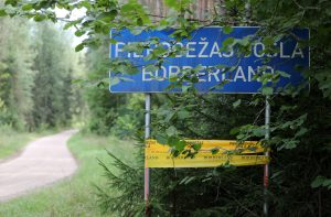 Ceļa zīme “Pierobežas josla” meža ceļa malā.