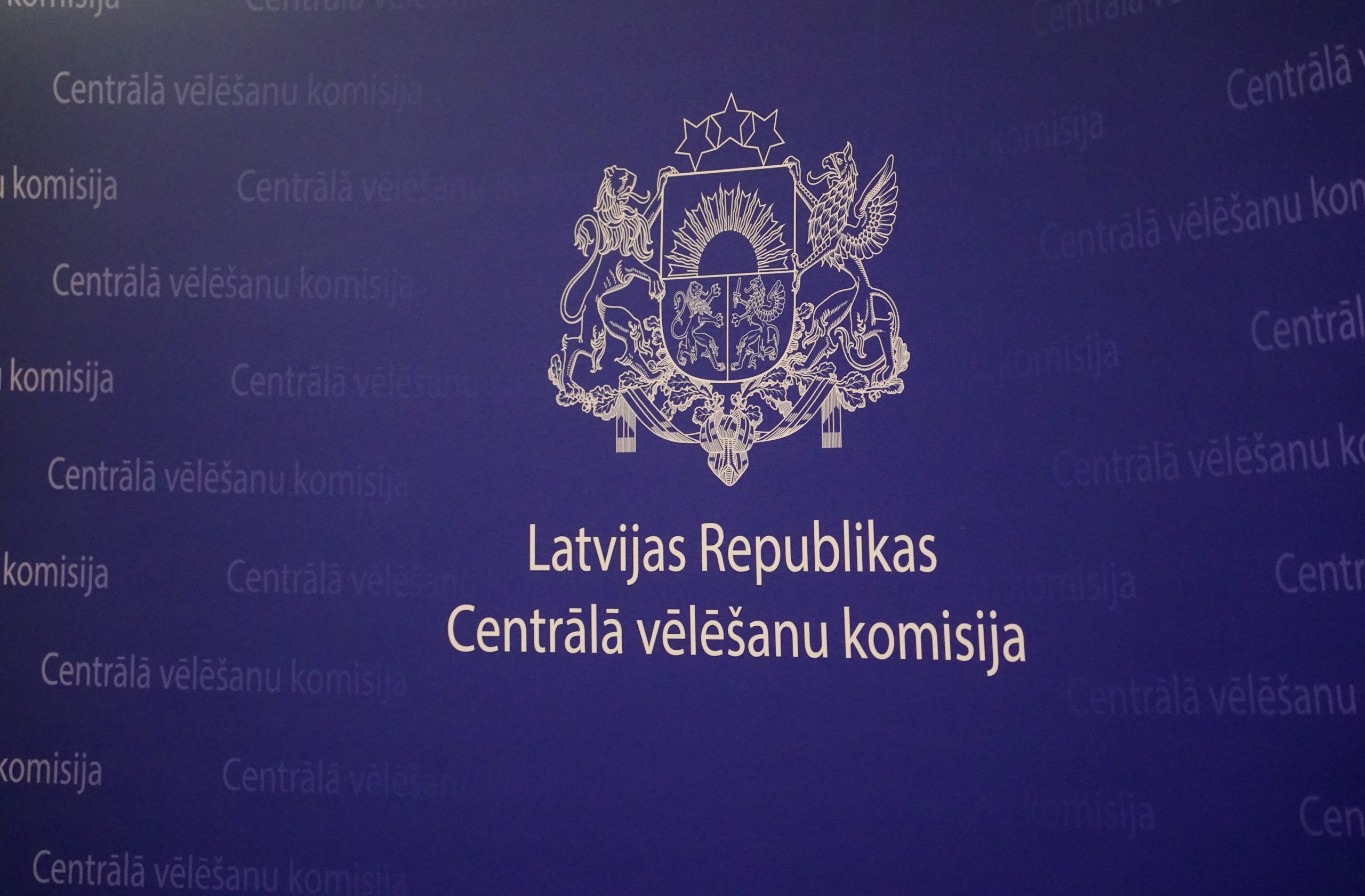 Latvijas Republikas Centrālās vēlēšanu komisijas logo uz zilā fona