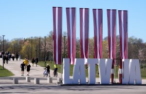 Latvijas karogi un uzraksts “LATVIA” Uzvaras parkā Rīgā