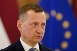 Zemkopības ministrs Armands Krauze oficiālā pasākumā pie Latvijas un Eiropas Savienības karogiem.