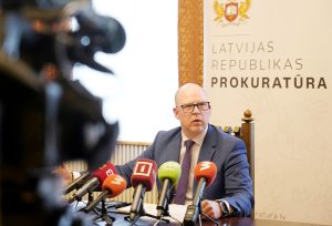 Ģenerālprokurors Armīns Meisters preses konferencē pie mikrofonu galda.