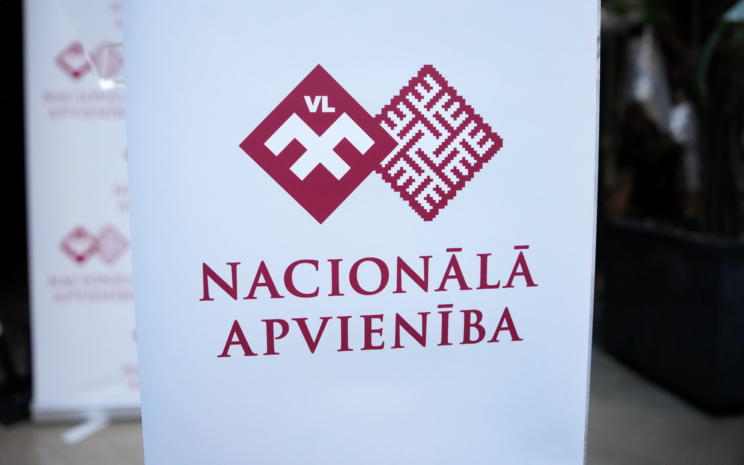 Partijas “Nacionālā apvienība” logo uz informatīvā stenda.