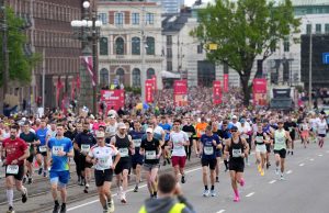 “Rimi” Rīgas maratona dalībnieki skrien pa pilsētas ielām.