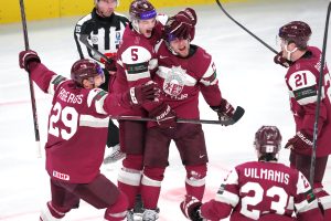 Latvijas hokeja izlases spēlētāji svin gūtos vārtus pasaules čempionāta spēlē.