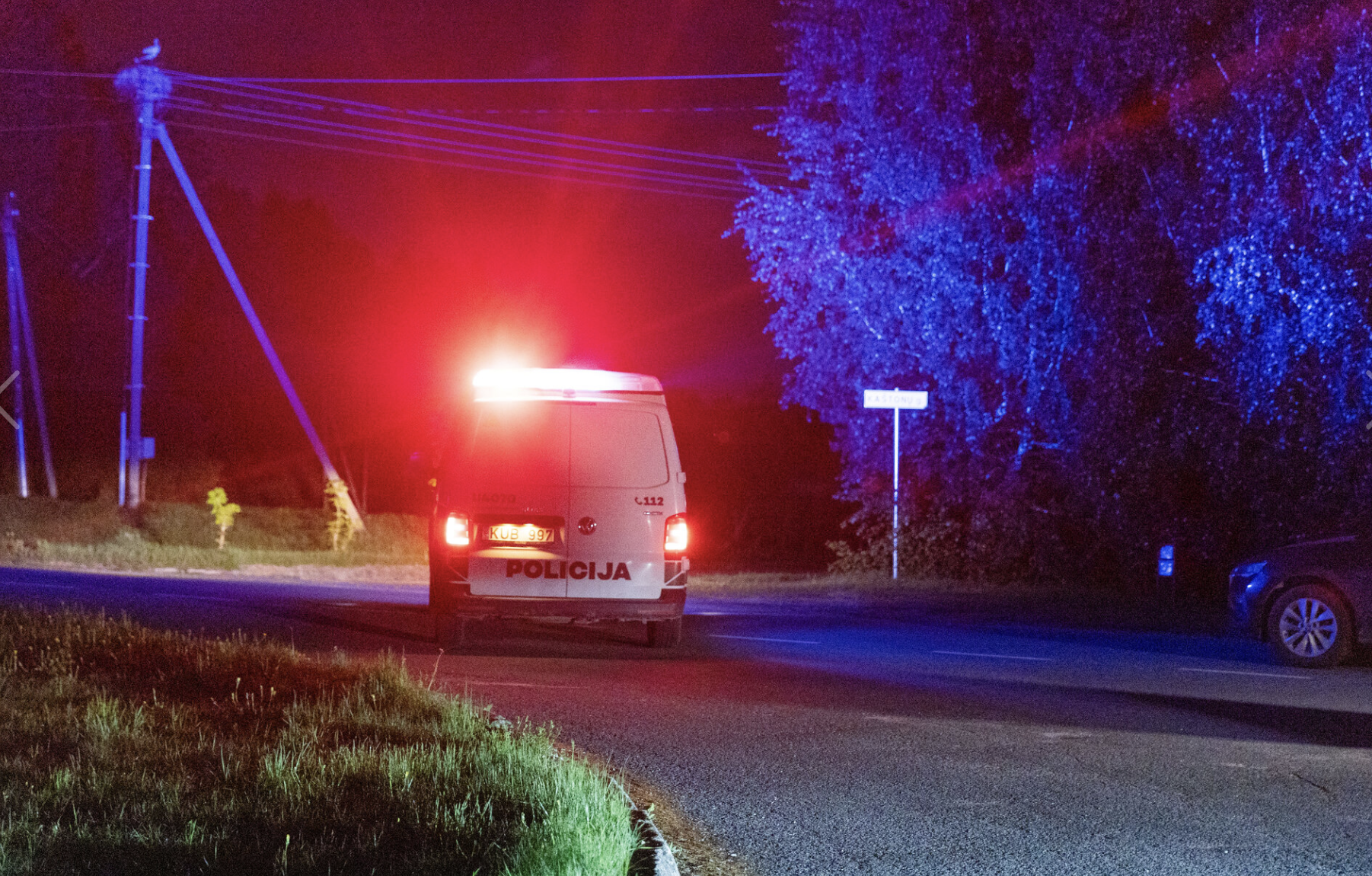 Policijas mikroautobuss ar ieslēgtām bākugunīm nakts laikā uz ceļa