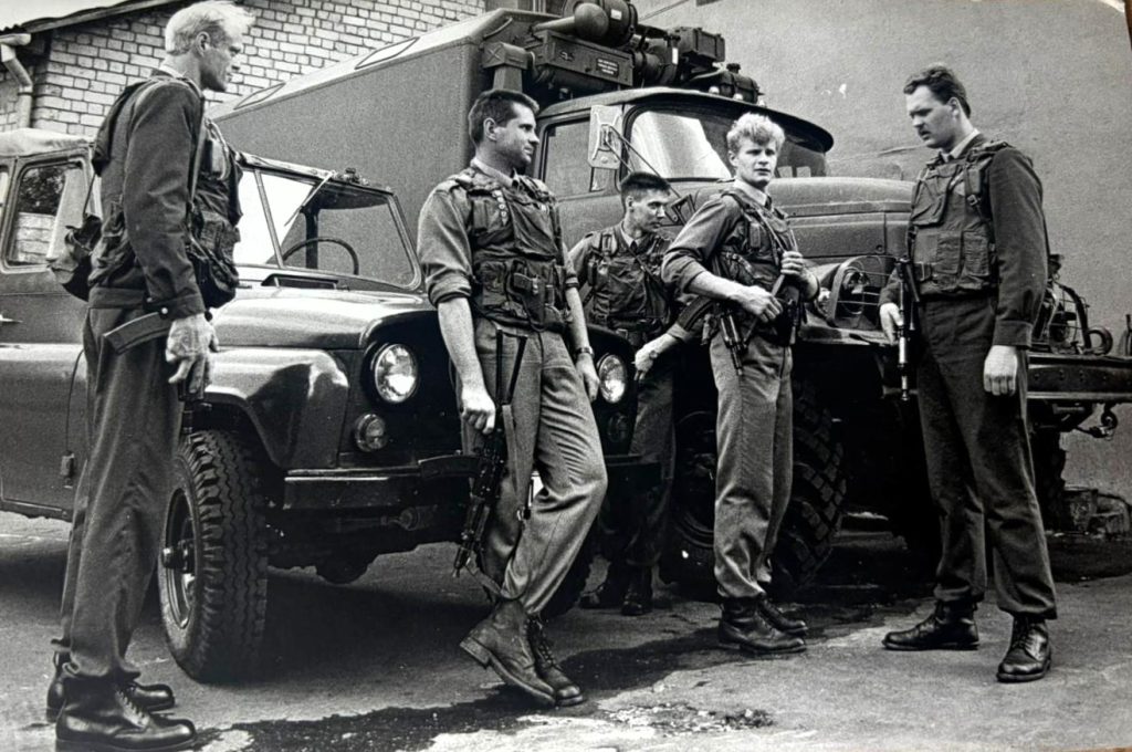 Bruņoti vīri pie militārā transporta