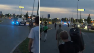 Policijas automašīnas un jaunieši pie tirdzniecības centra “Sāga” vakara stundās.
