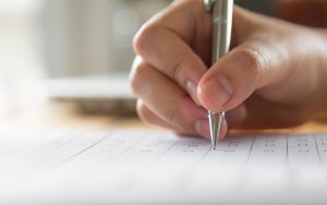 Cilvēks ar pildspalvu aizpilda dokumentu