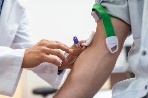 Medicīnas darbinieks veic asins analīžu paņemšanu pacientam