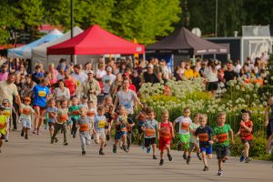 Bērni un ģimenes piedalās bērnu skrējienā “Izskrien Rīgu” pasākumā Uzvaras parkā, pulcējot daudzus dalībniekus un skatītājus.
