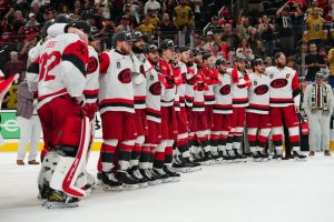 Karolīnas "Hurricanes" hokejisti ar čempionu cepurēm uz ledus pēc Stenlija kausa izcīnīšanas.