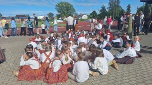 Bērni tautastērpos pulcējušies pie stadiona pirms deju priekšnesuma kultūras pasākuma laikā.