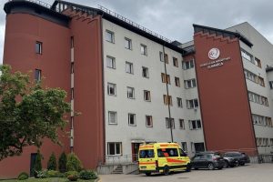 Dobeles un apkārtnes slimnīcas ēka ar pie ieejas novietotu neatliekamās medicīniskās palīdzības automašīnu.