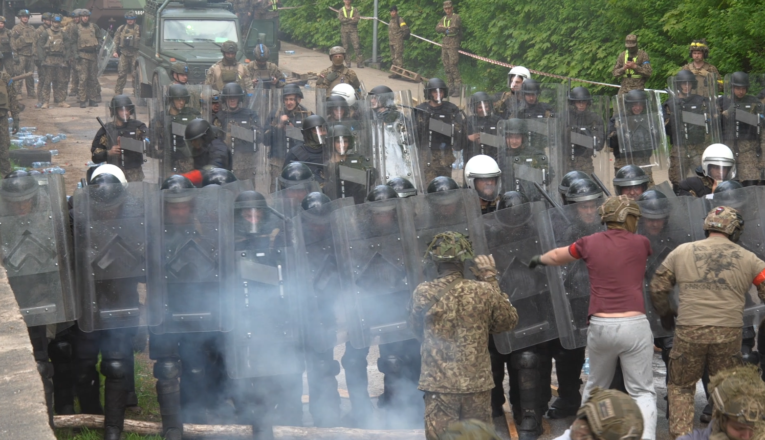 Militārās mācības laikā karavīri un kārtības uzturēšanas vienība pilnā ekipējumā izspēlē pūļa kontroles un nemieru ierobežošanas scenāriju.