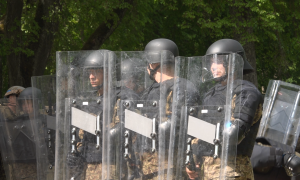 Kārtības uzturēšanas vienības dalībnieki aizsargekipējumā un ar vairogiem militāro mācību laikā.