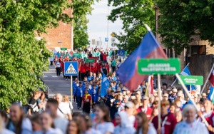 Latvijas Jaunatnes olimpiādes dalībnieku gājiens Valmierā ar jauno sportistu delegācijām un pašvaldību zīmēm.