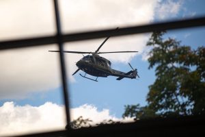 Militārais helikopters lido virs pilsētas pretterorisma mācību laikā.
