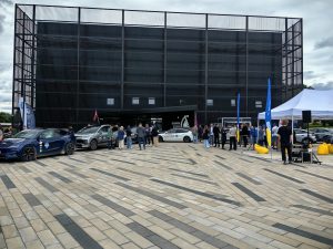 Elektroauto un rallija dalībnieki pie Cēsu Kosmosa izziņas centra Baltijas elektromobiļu rallija laikā.