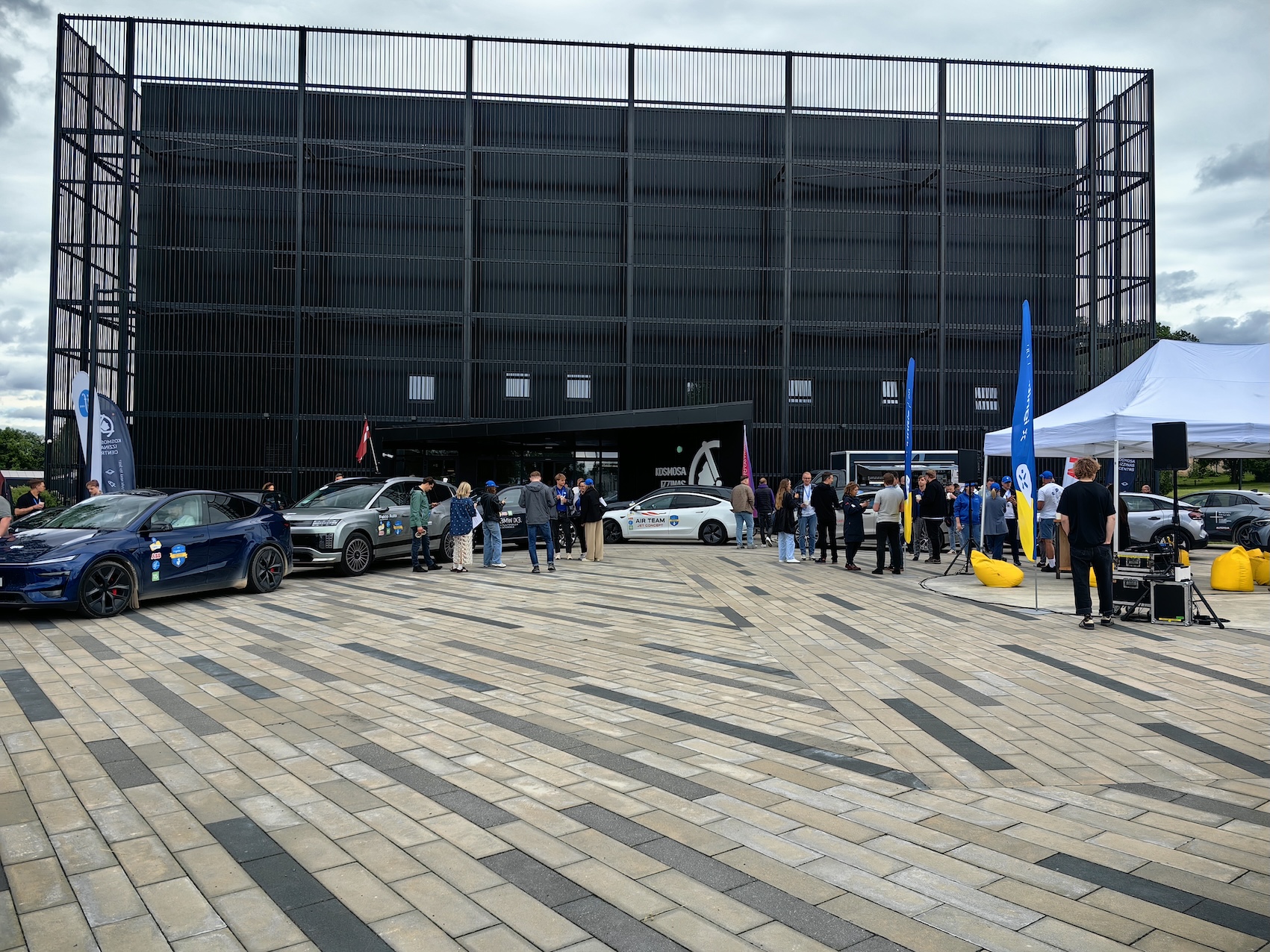 Elektroauto un rallija dalībnieki pie Cēsu Kosmosa izziņas centra Baltijas elektromobiļu rallija laikā.