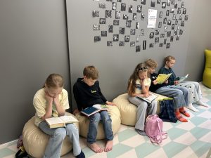 Bērni bibliotēkā lasa grāmatas iniciatīvas “Vasarā lasām kopā” laikā.