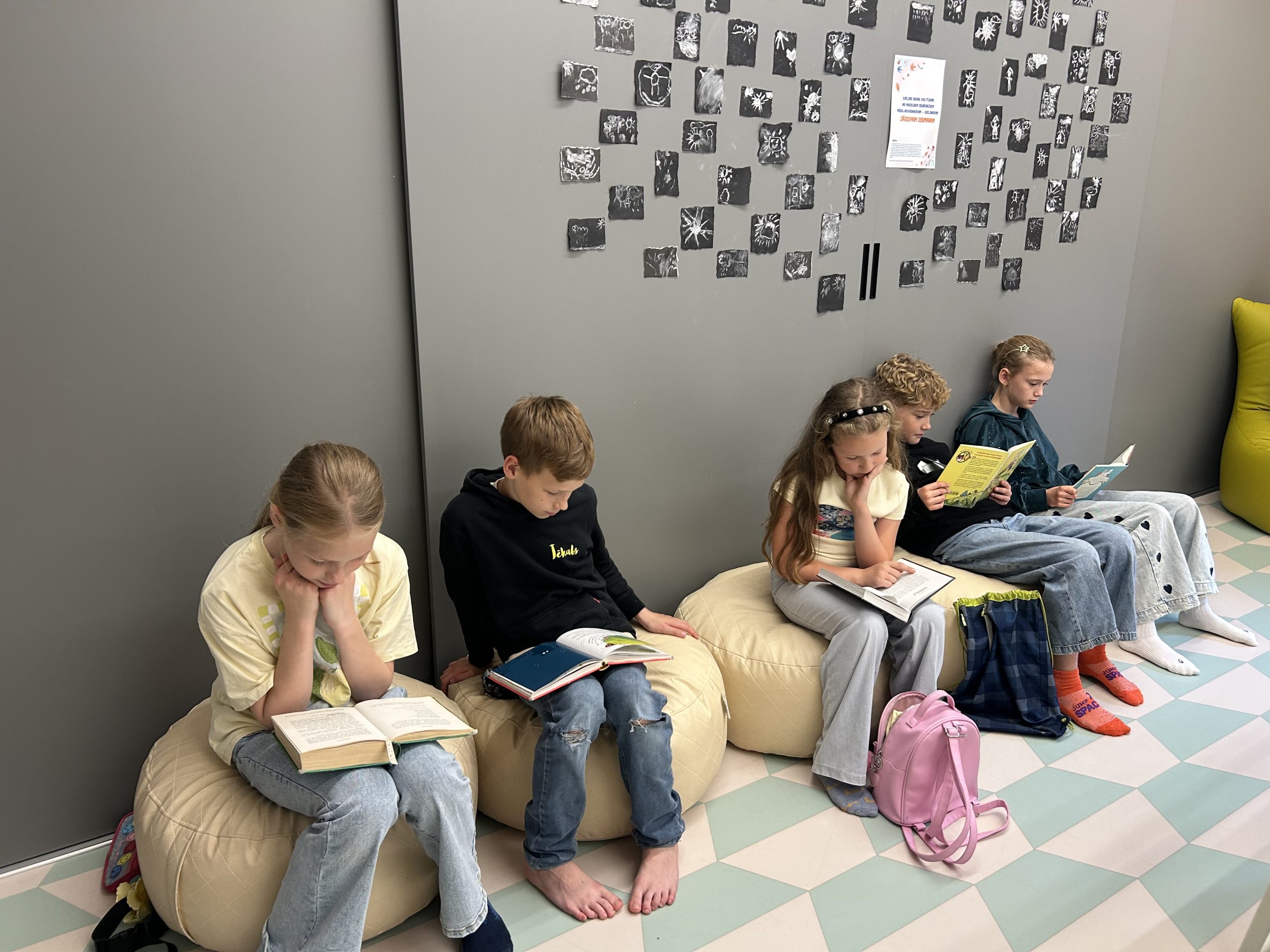 Bērni bibliotēkā lasa grāmatas iniciatīvas “Vasarā lasām kopā” laikā.