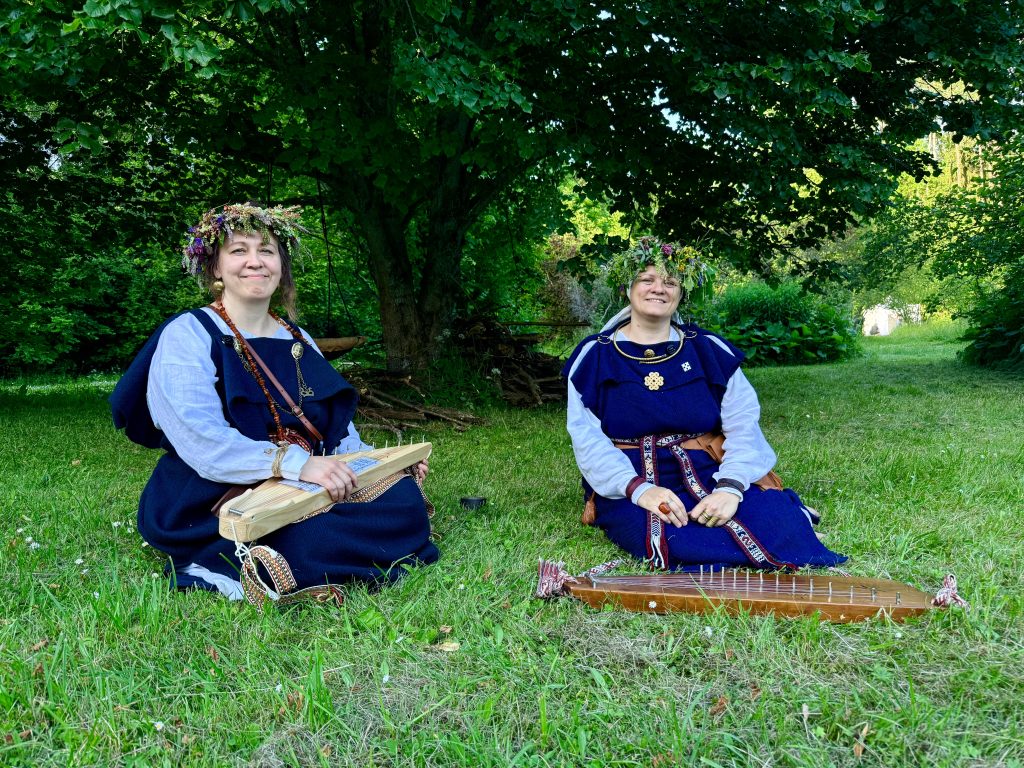 Divas koklētājas ar ziedu vainagiem saulgriežu svinībās.
