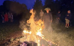 Cilvēki pulcējušies ap ugunskuru saulgriežu vakarā.