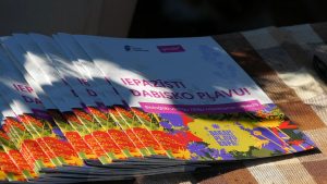 Uz galda saliktas informatīvās brošūras par dabisko pļavu atpazīšanu.