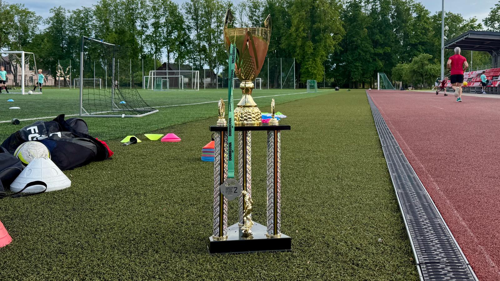 Kauss un medaļa futbola laukumā pēc bērnu futbola turnīra.